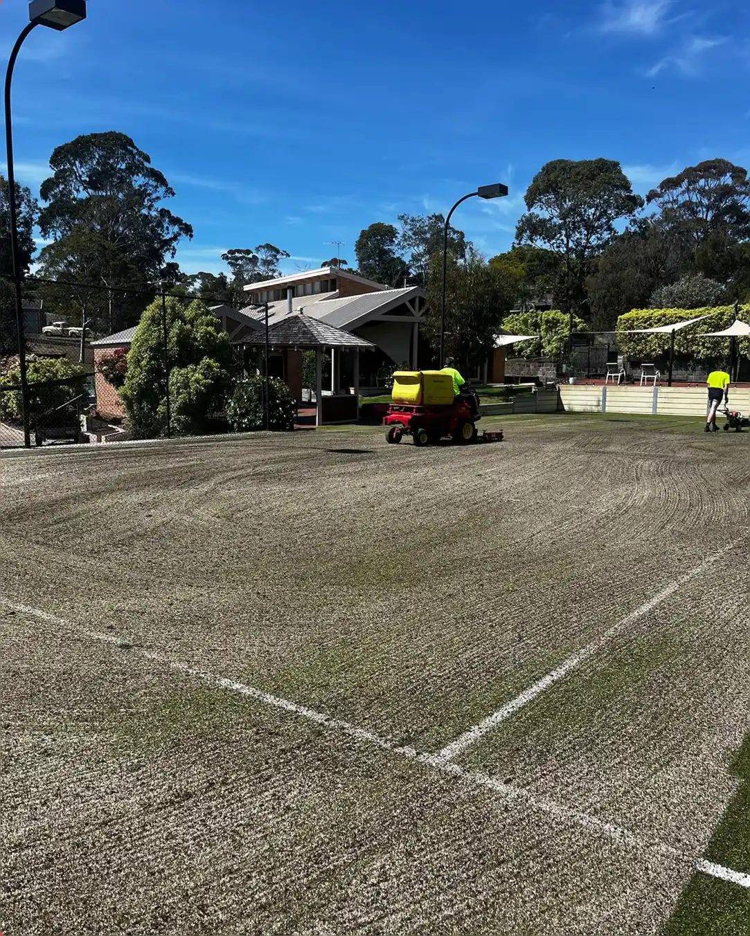 The same tennis court before, worn and dirty with faded lines