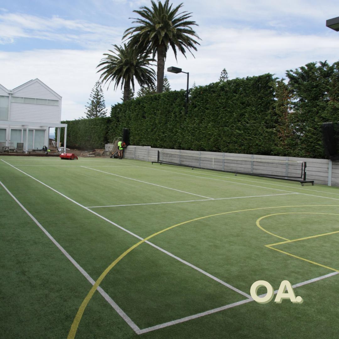 Walled grass court after, clean and green with bright lines