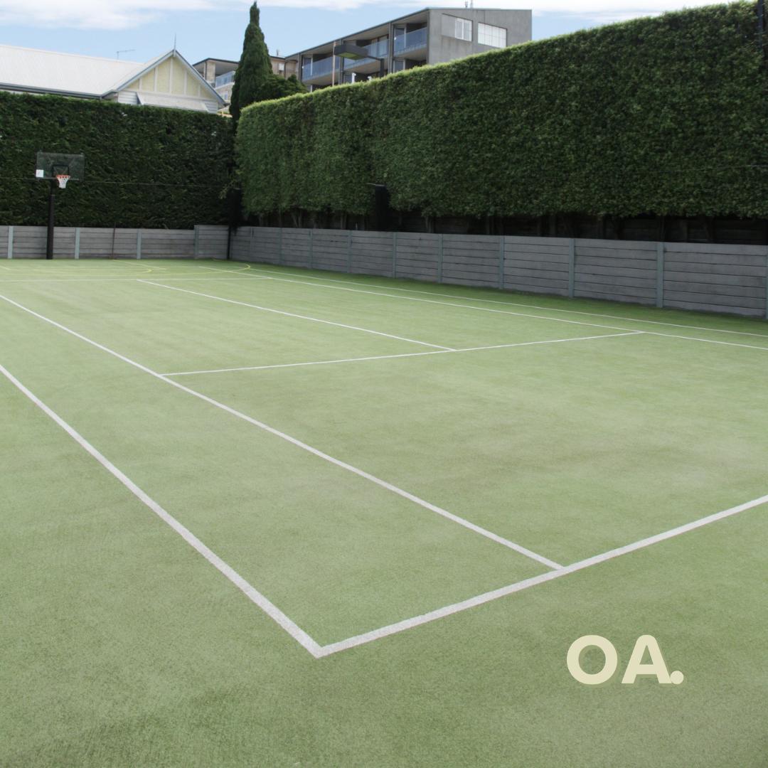 Walled grass court after, clean and green with bright lines